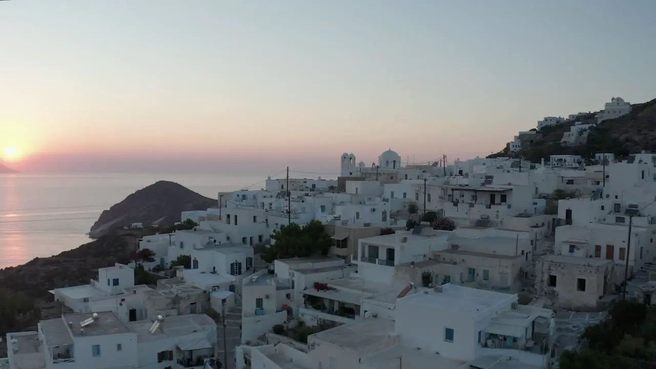 Beautiful Aerial view over Generic Greek Village Small Town with Ocean View Sunset