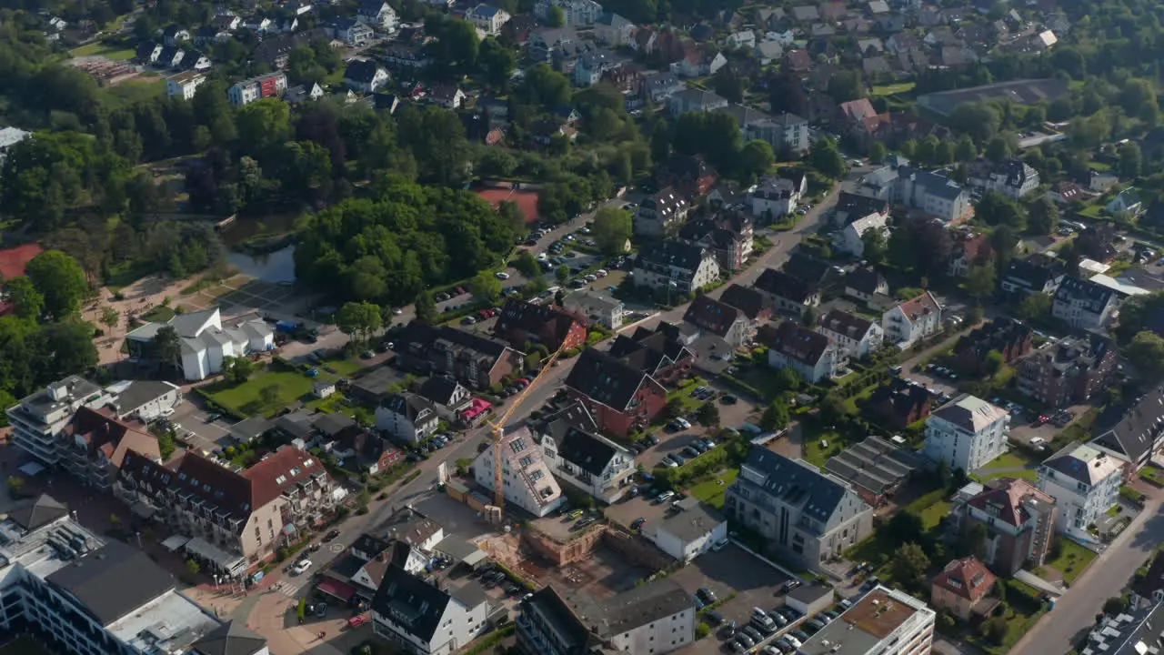 High aerial view of residential area houses in Scharbeutz Germany forward tilt up reveal amazing countryside landscape day