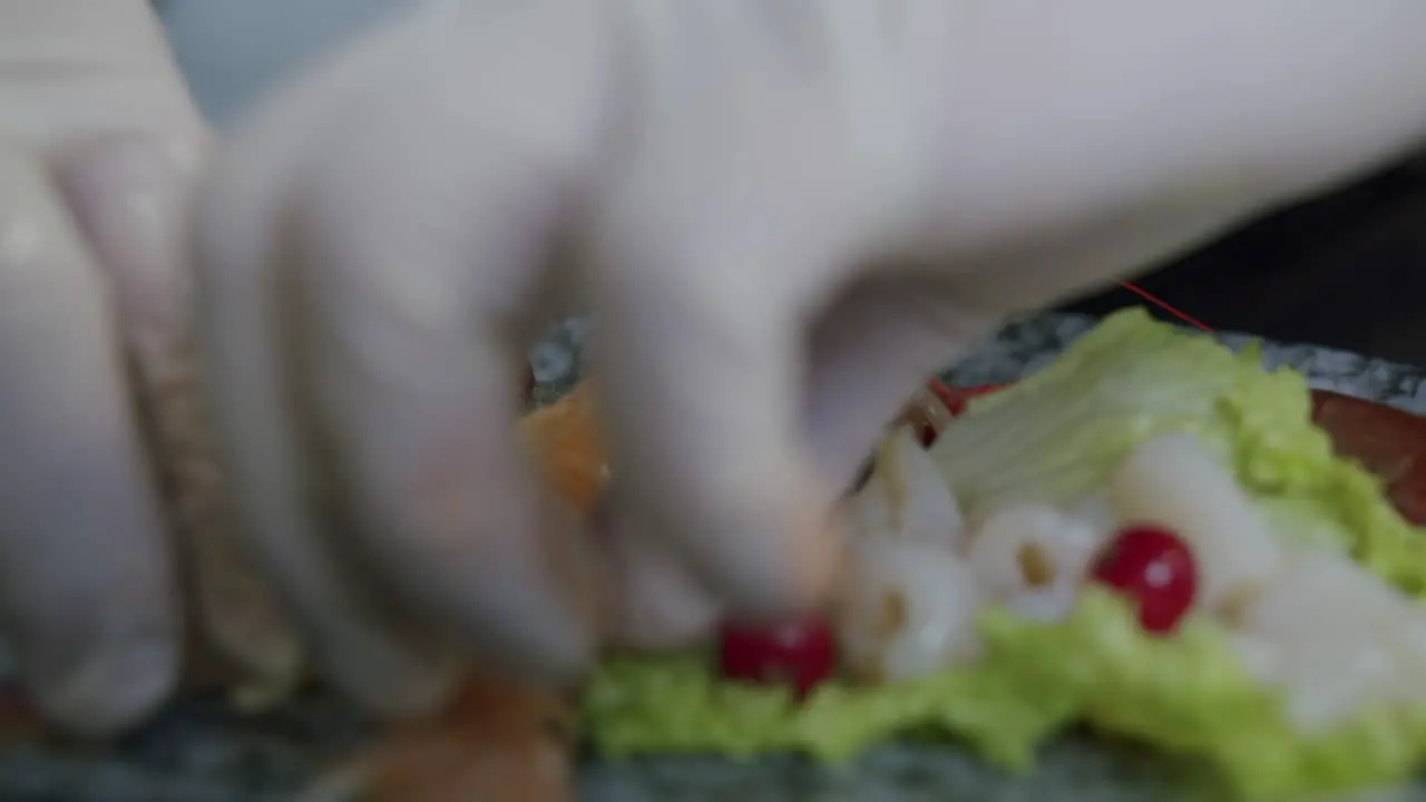 Detail of a professional chef preparing a plate of prawns in his kitchen