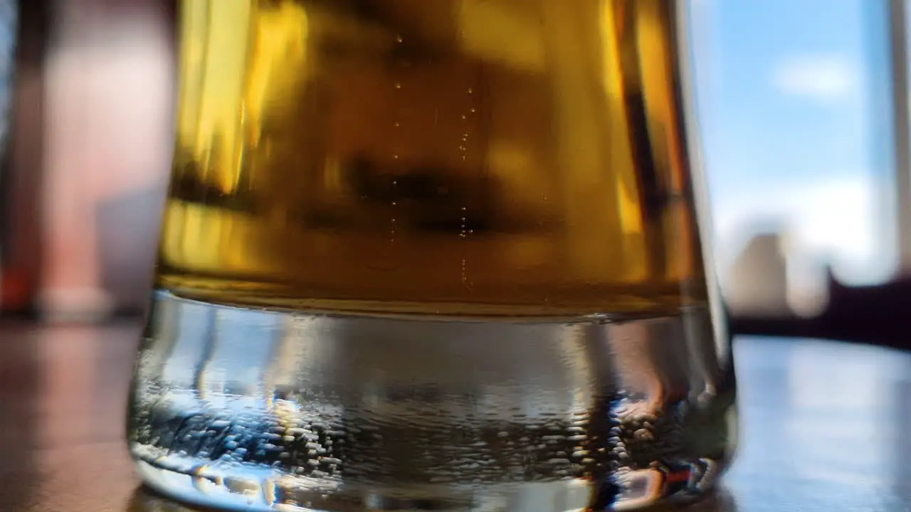 Small bubbles rise and float up slowly from the bottom of a glass of beer