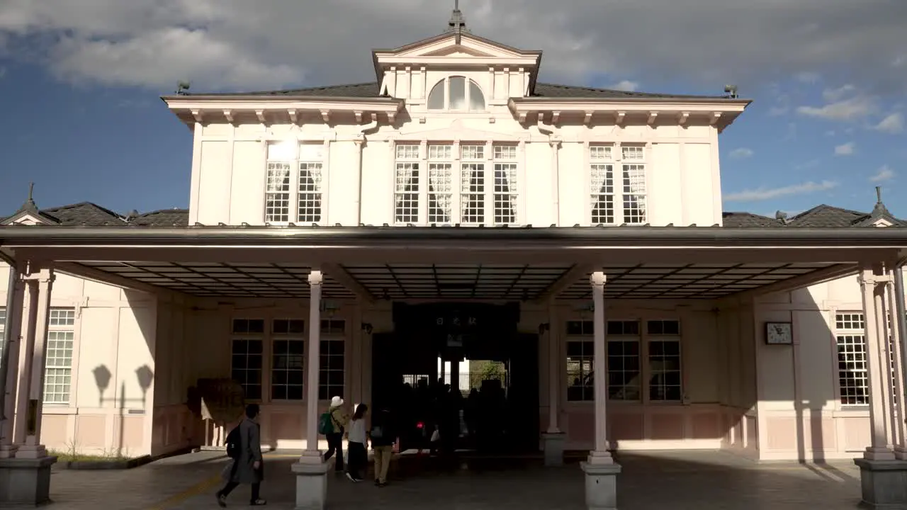 Front Entrance To JR Nikko Station Building With Commuters Walking Past