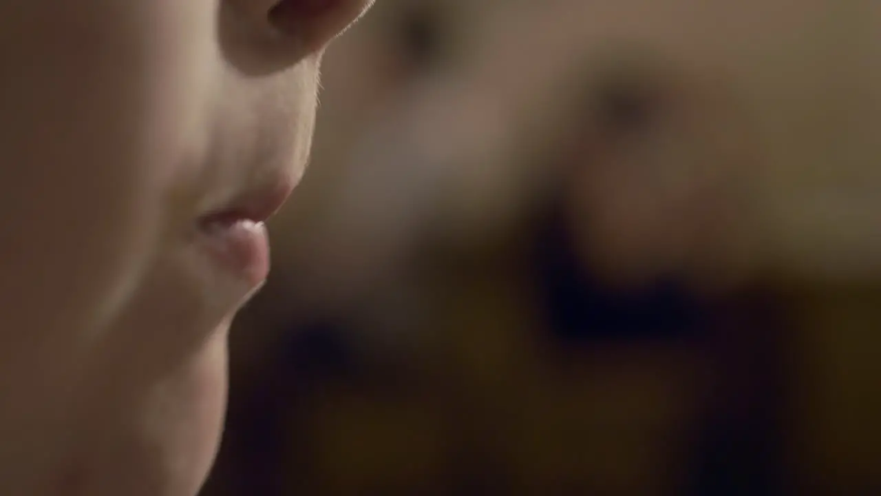 Close up slow motion of young boy's mouth chewing with copy space to the right of frame