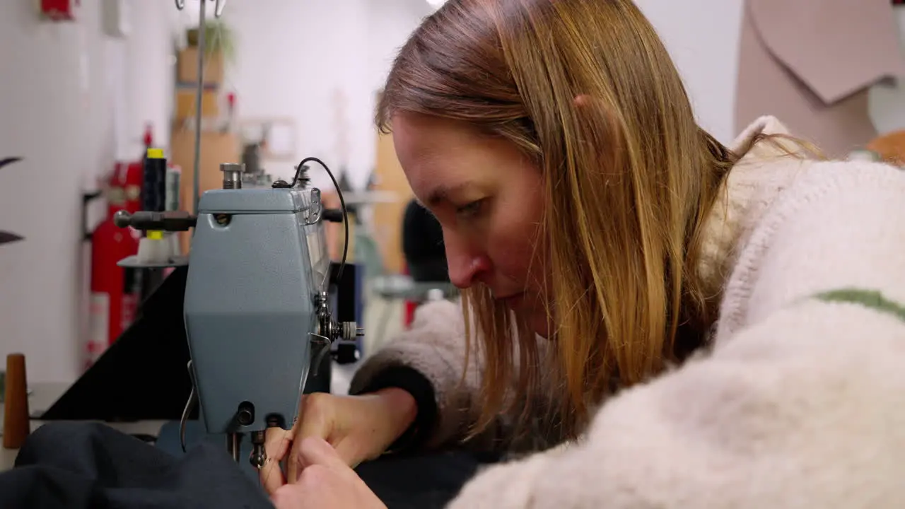 Slow and sustainable female fashion designer maker using a sewing machine