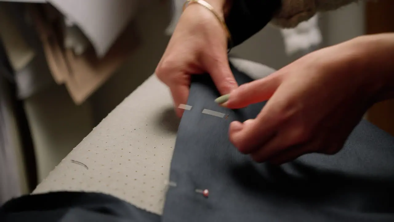 Seamstress pinning fabric material preparing to sew