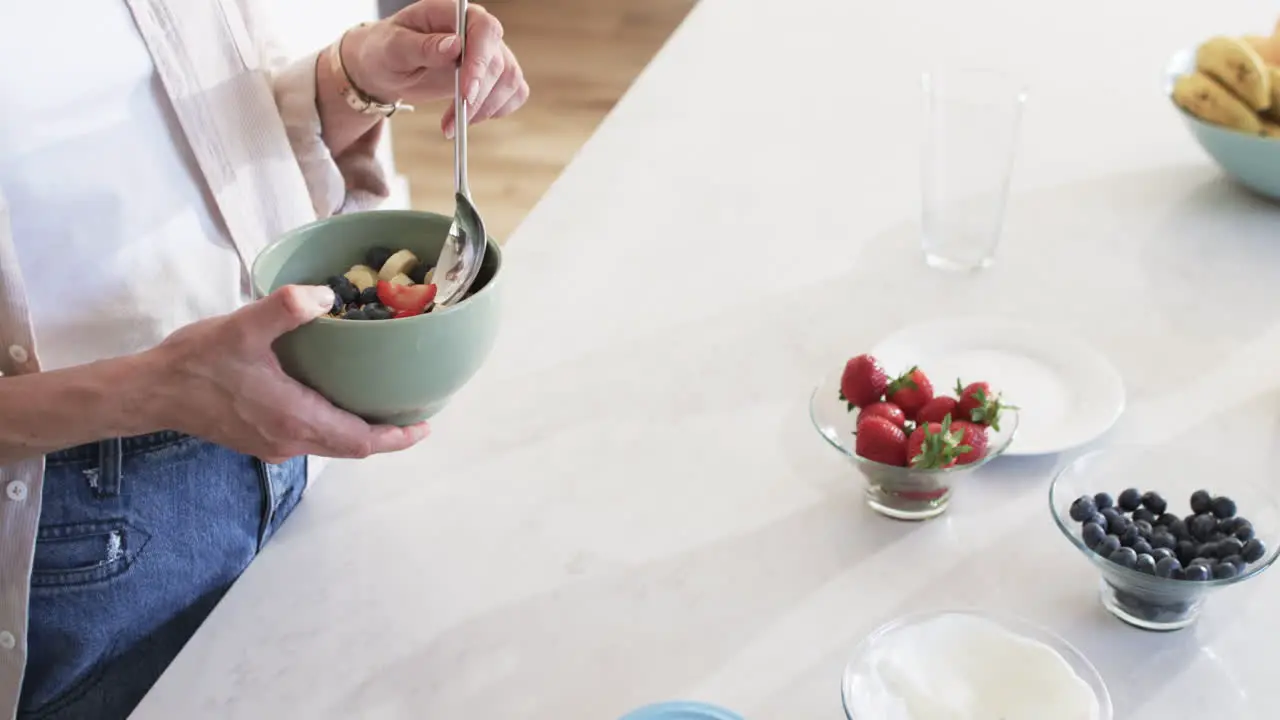 Middle-aged Caucasian woman enjoys a healthy breakfast at home