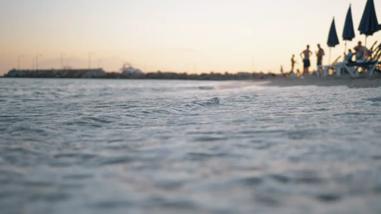 Sea waves washing the shore of resort at sunset