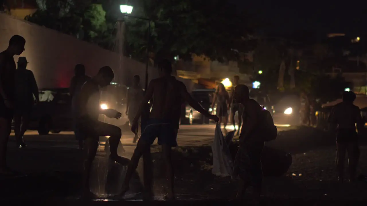 Several men taking beach shower at night