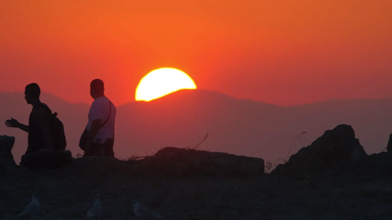 Men walking against sunset and mountain background