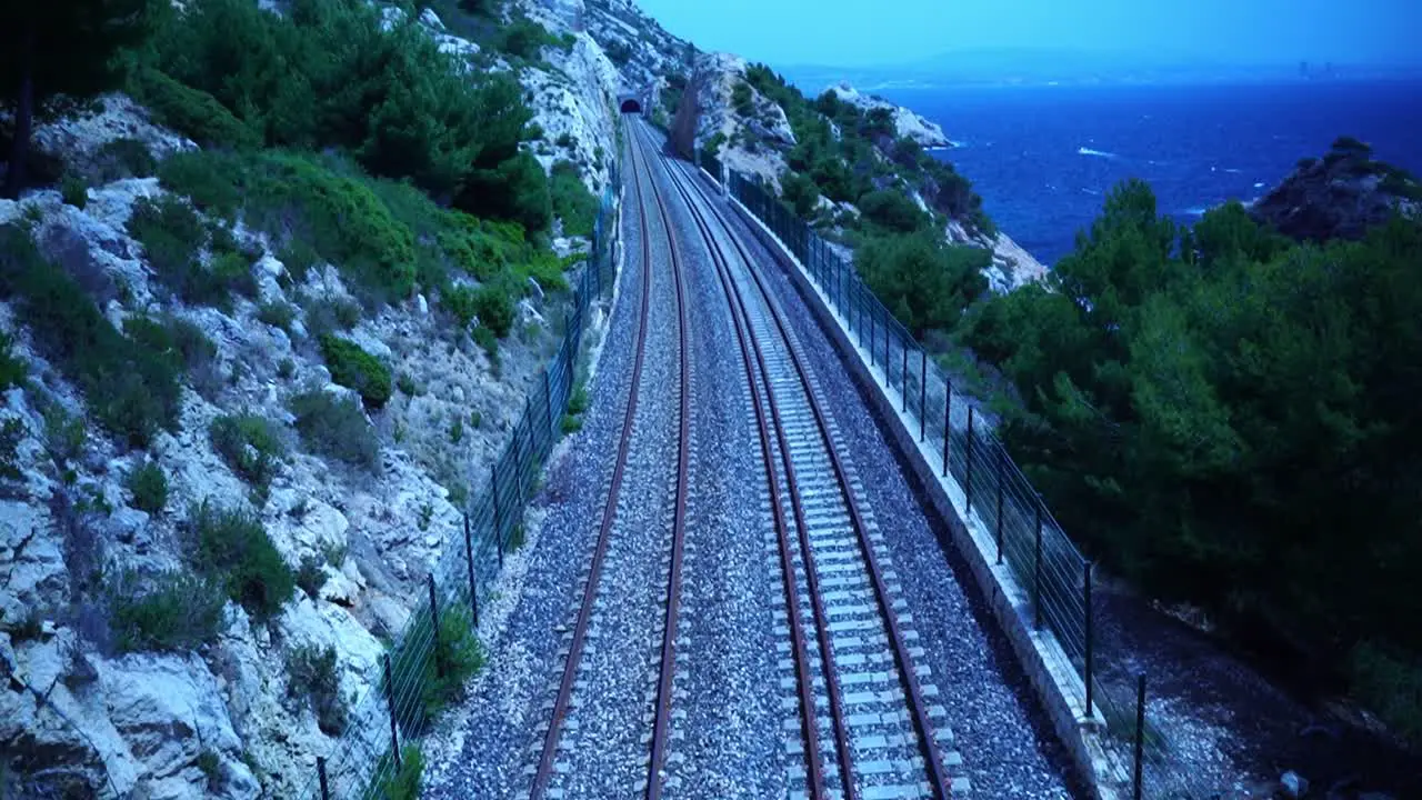 railway line on the coast of southern france leads along the sea into a tunnel in good weather and sun