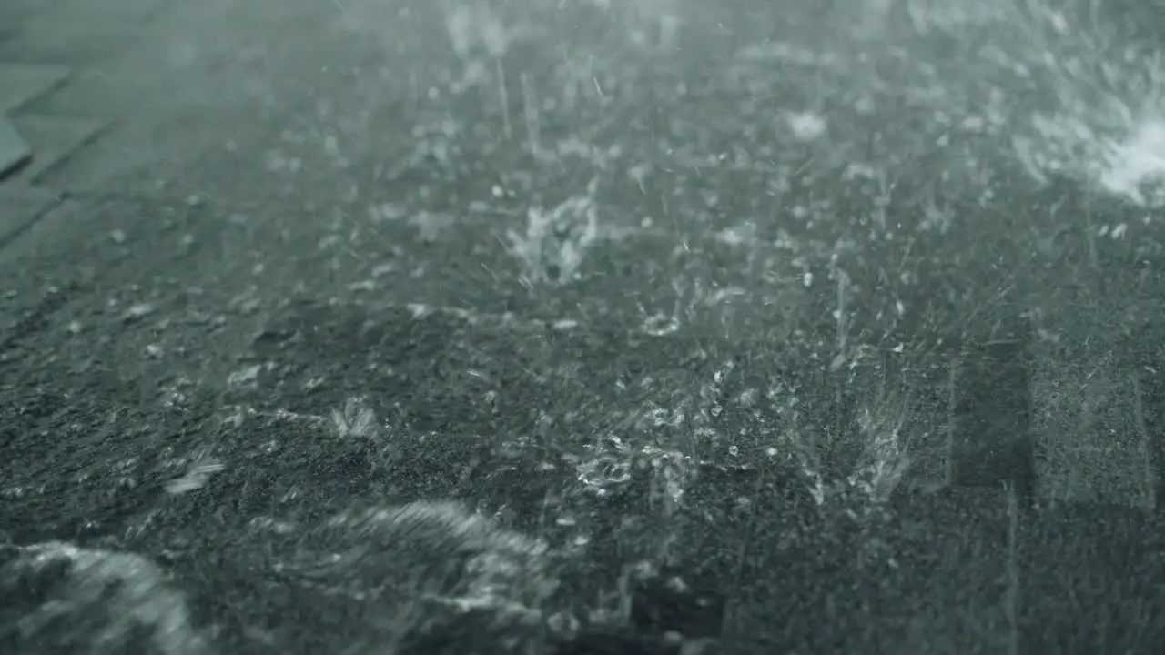 Heavy rain pours on the roof of a house made of soft shingles