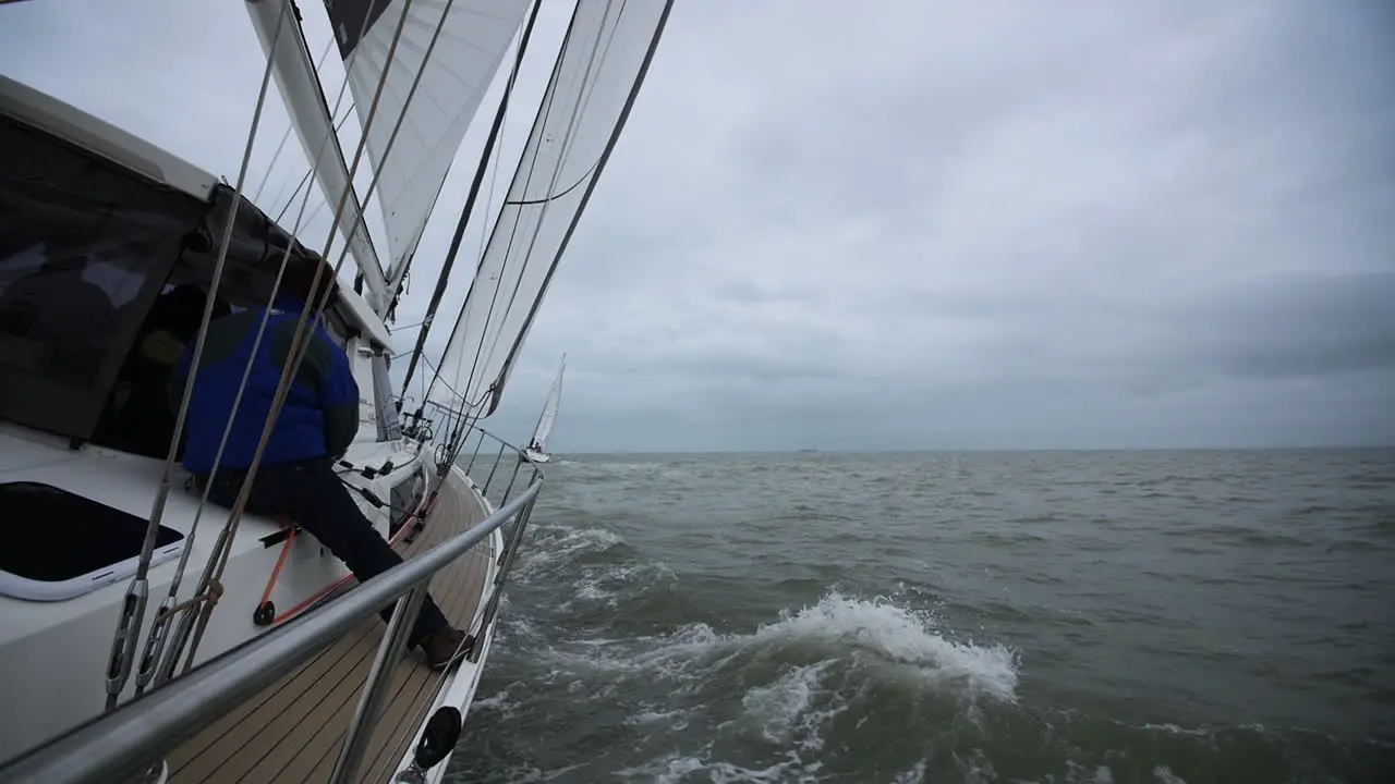 Sailing yachts in France with a sailor sitting on deck