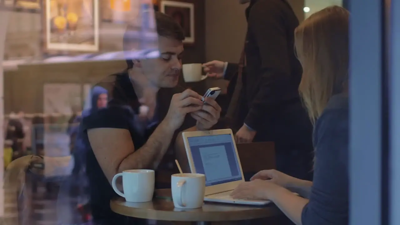 Man and woman work in the restaurant using gadgets