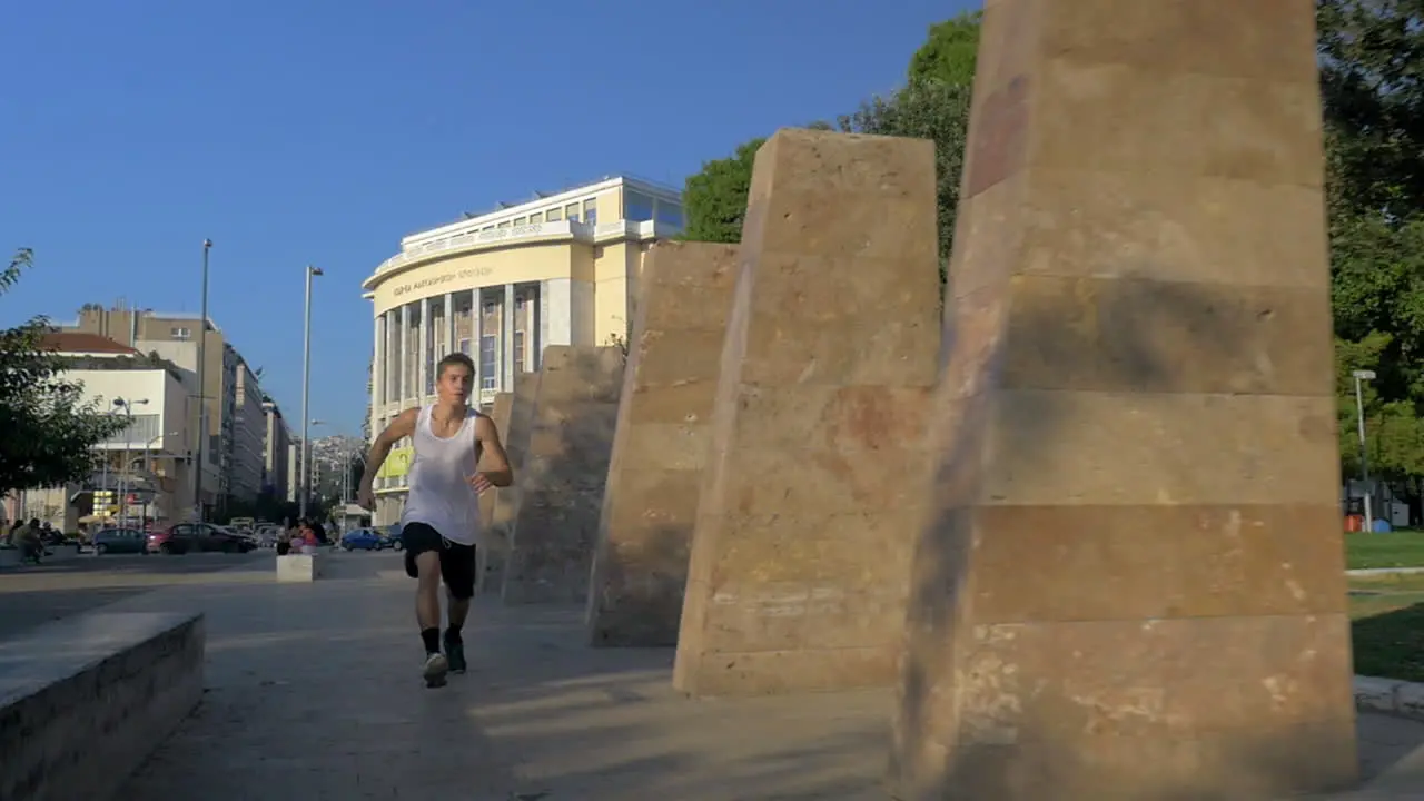 A guy doing acrobatic tricks in alley