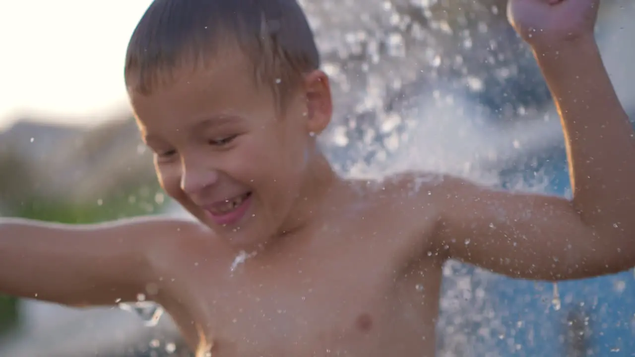 Joyful boy dancing under the beach shower