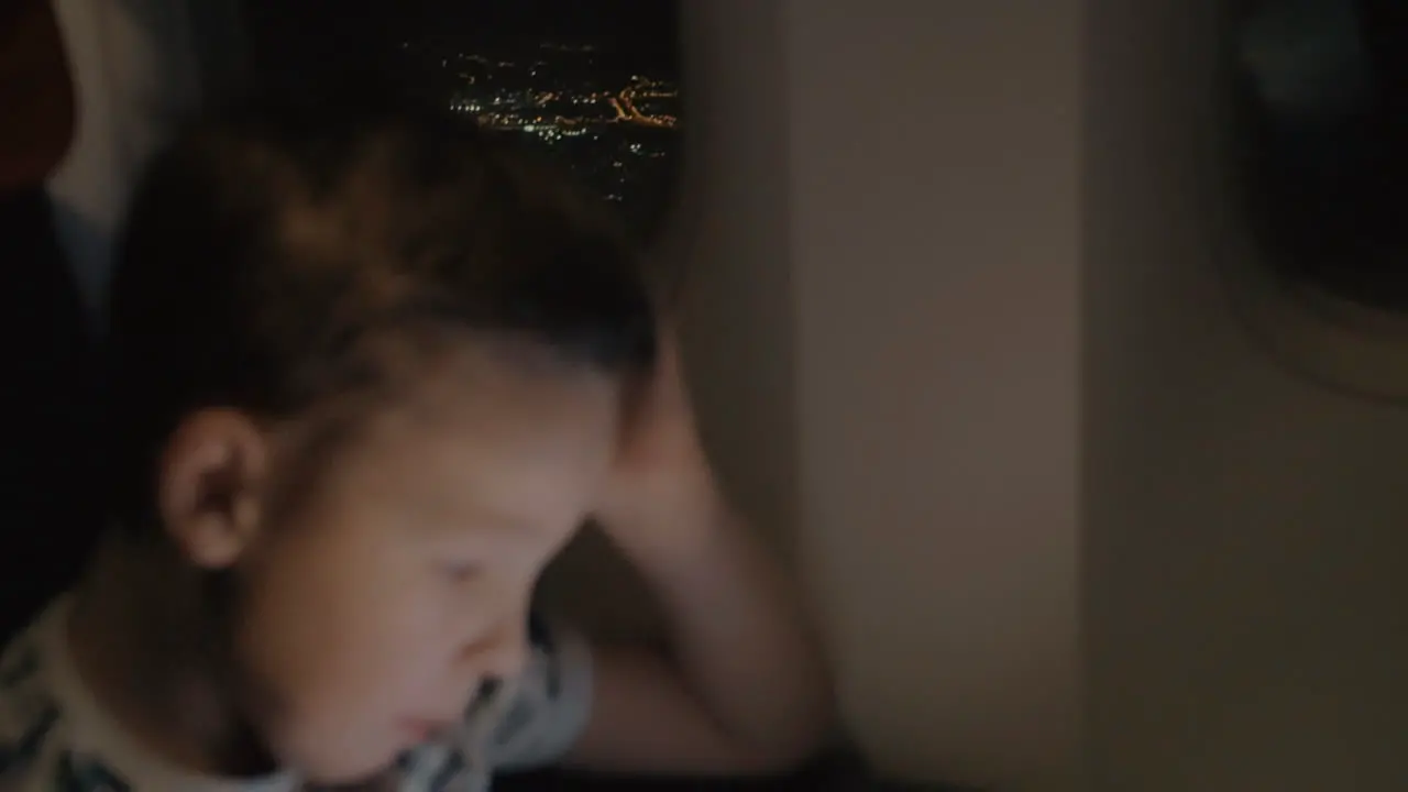 Kid waiting for plane landing and playing game on pad to pass the time