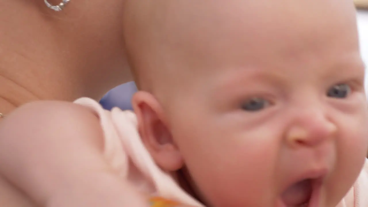 Sleepy baby girl in mothers hands