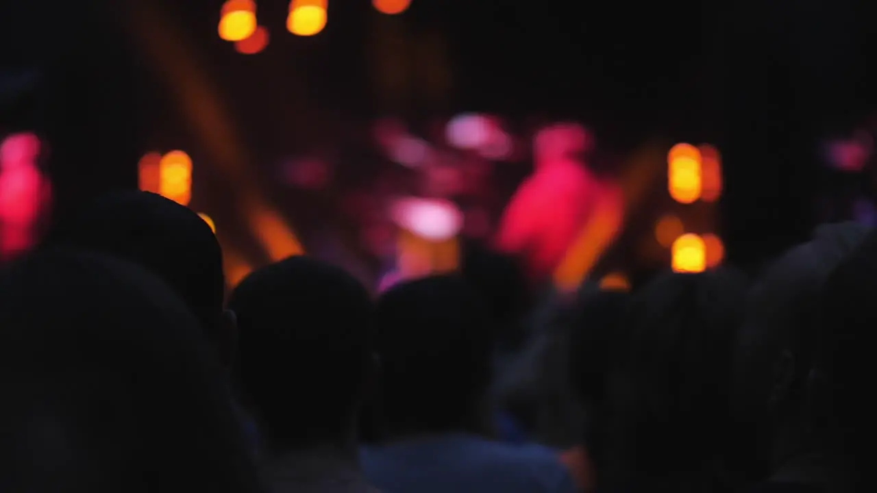 Bright stage lights in the dark and audience enjoying the concert