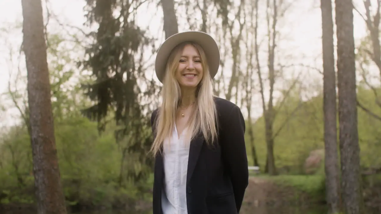 Portrait Of A Happy Blonde Woman With Hat Standing In The Park And Looking At The Camera 2