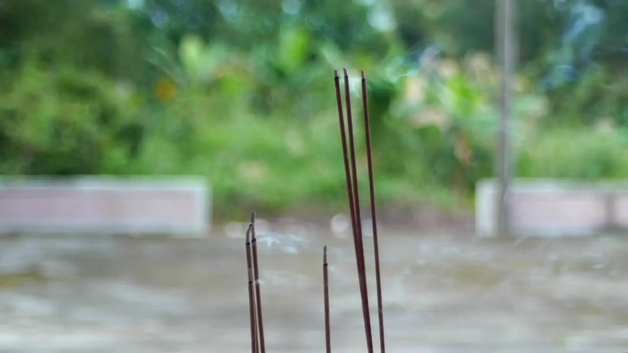 Tall Chinese incense sticks burning and blowing smoke