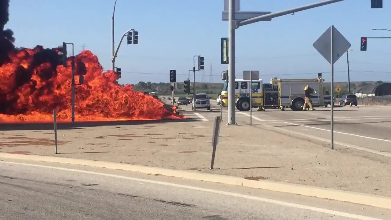 A car Kia Soul fire burns in an intersection with a fire truck nearby near Ventura California