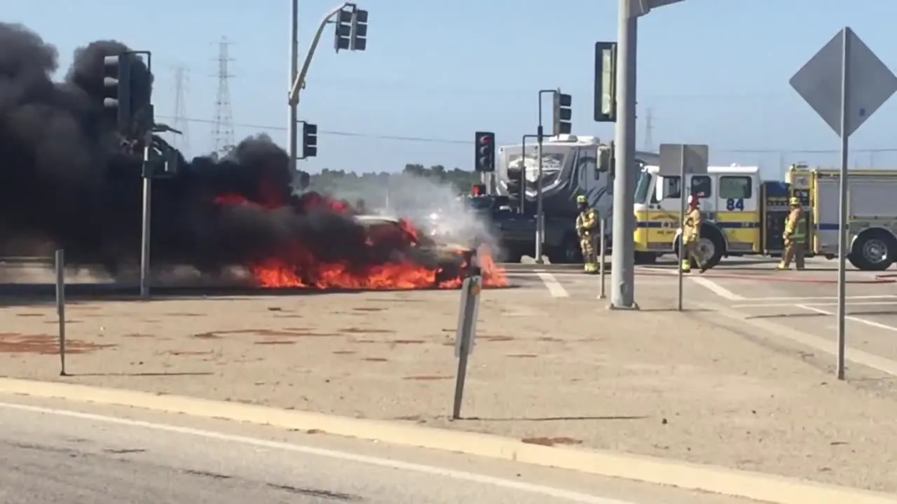 A car Kia Soul fire burns in an intersection with a fire truck nearby near Ventura California 2