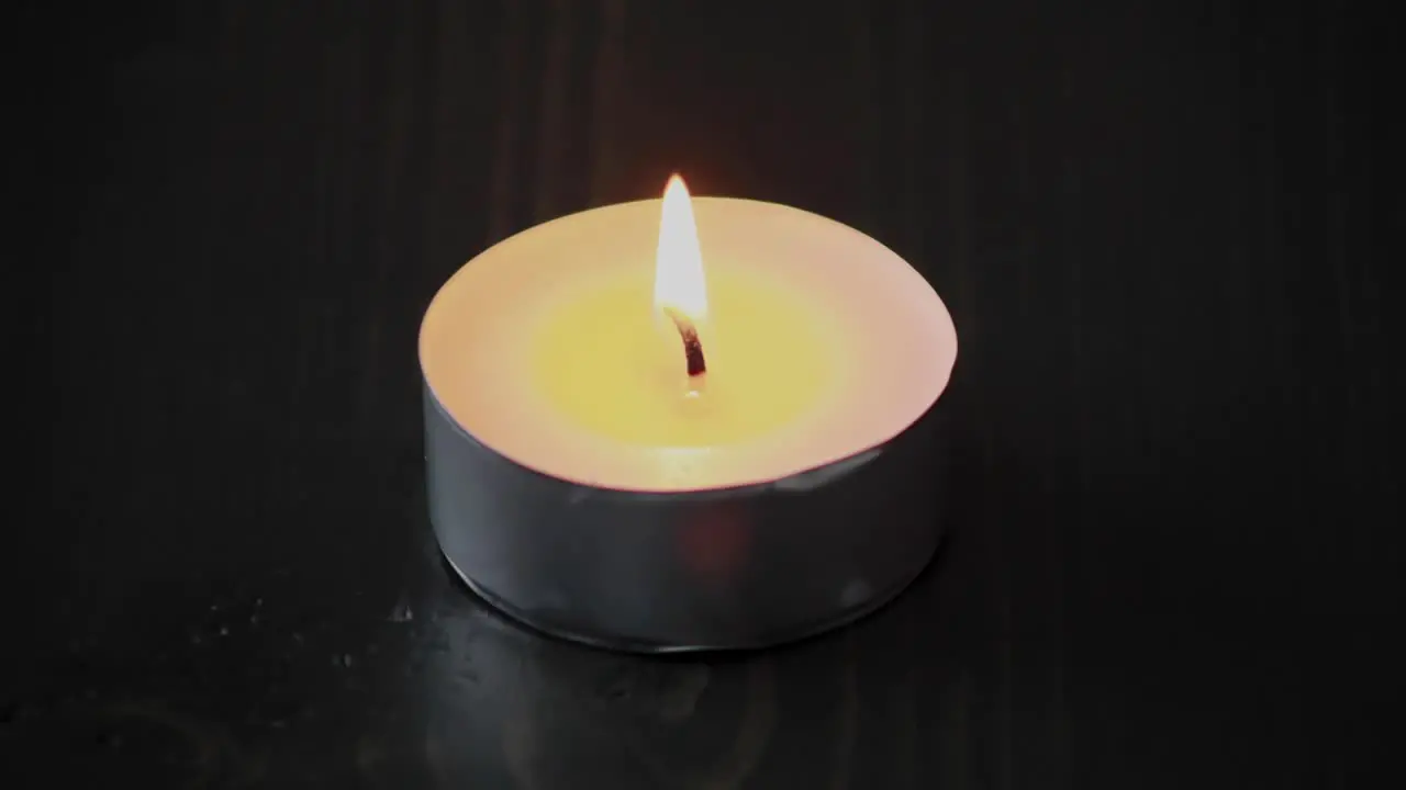 Time lapse of a tea light candle lighting and melting the wax