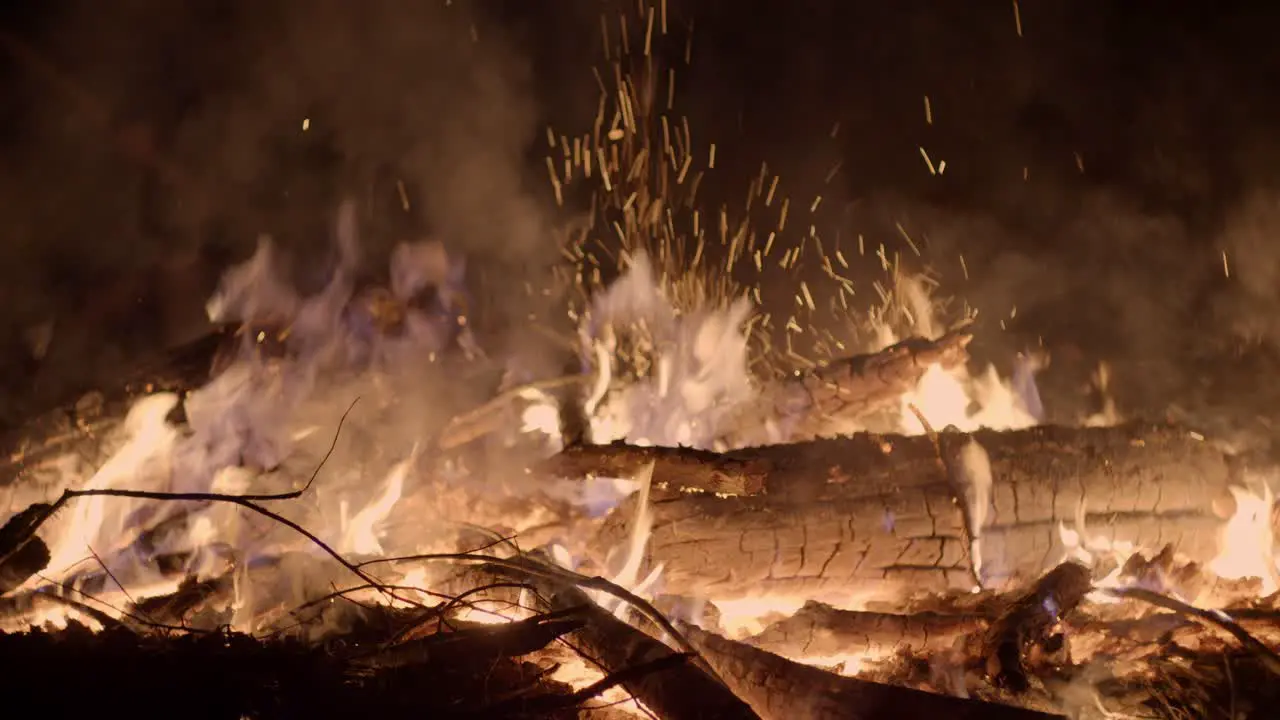 Close up shot of logs of wood burning on a cold winter night with open flames rising up at a Christmas market winter wonderland