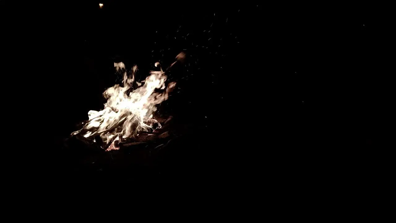 Sparks fly off a burning campfire