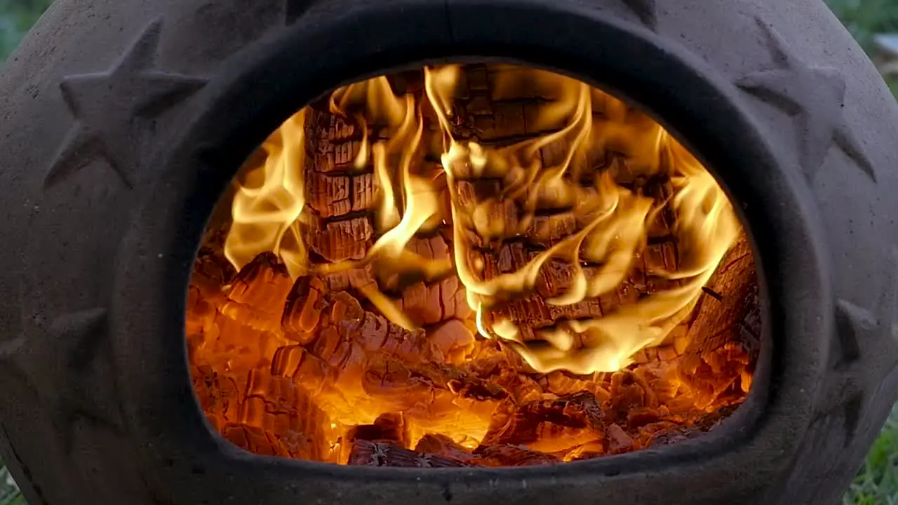 SLO-MO Burning embers in a terra-cotta chimenea during late evening