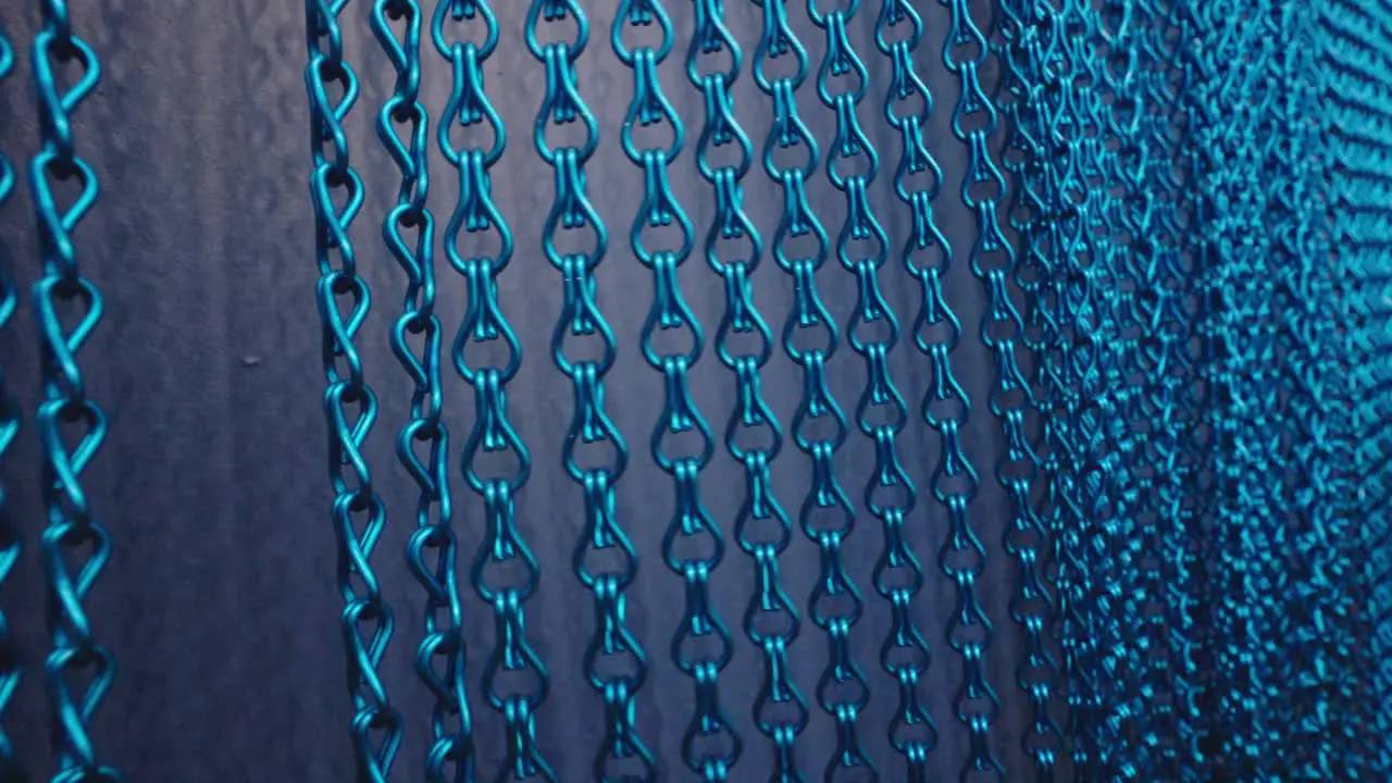 hand passes over blue metallic rings curtain background