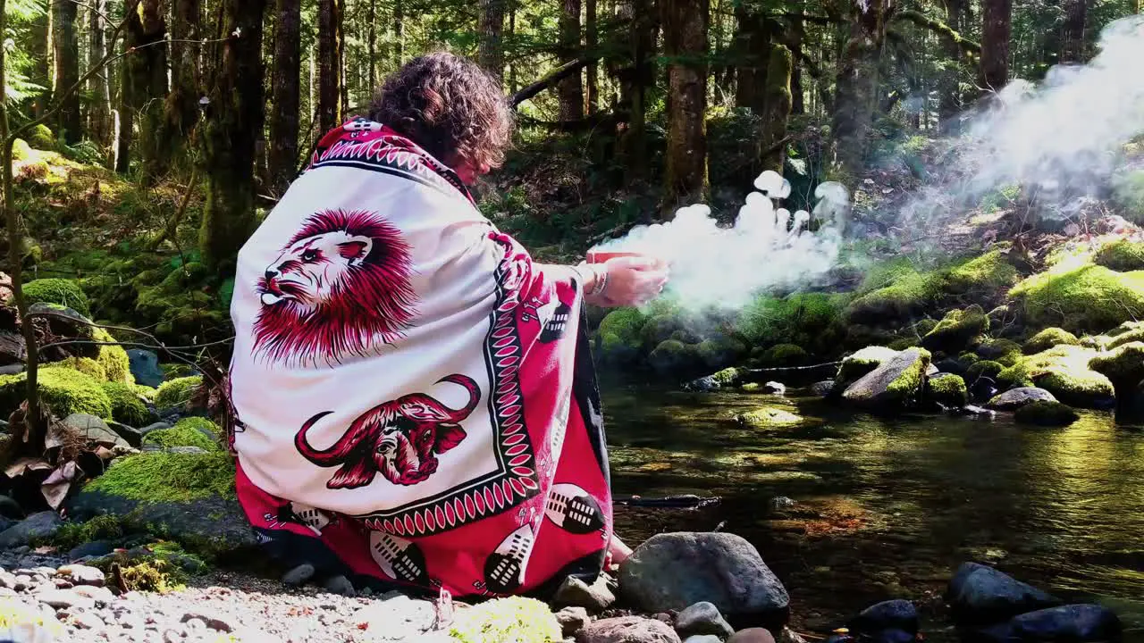 Sangoma Shaman woman at the creeks edge with a burning bowl speaking with her Ancestors