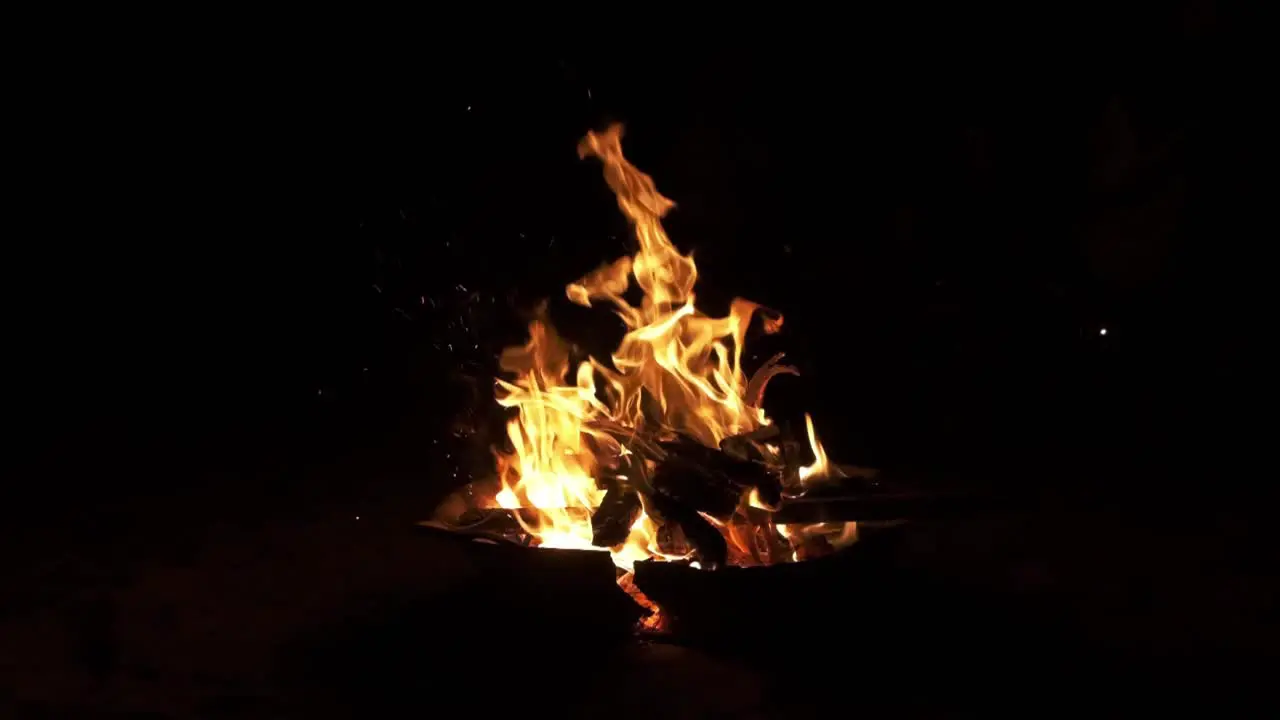 camp fire burns wood night shot in slow motion