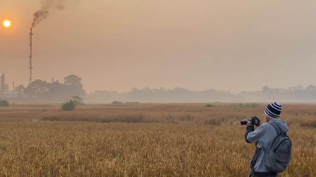 Photographer with camera documenting polluted area near Gas Burning Plant