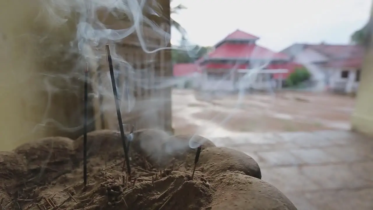 Close up static view of smoke coming out of the burning incense in front of an Asian Buddhist temple in Sri Lanka