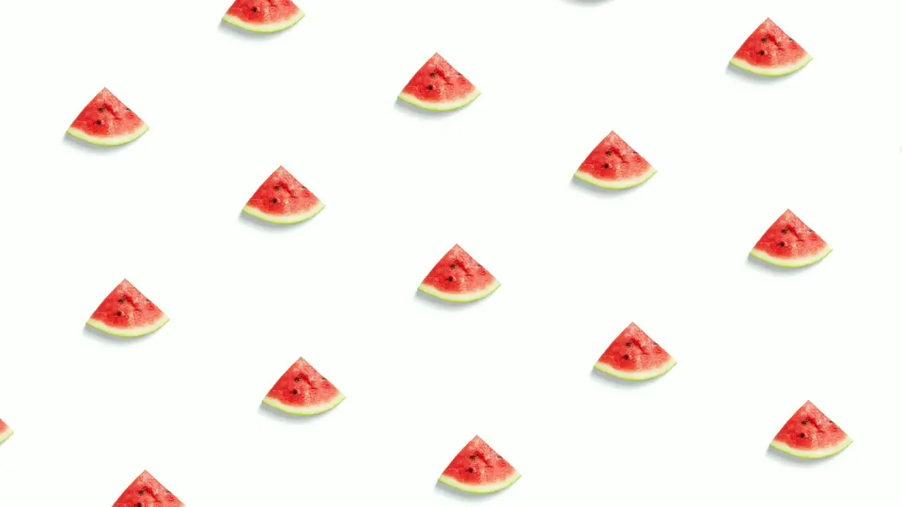 Animation of slices of watermelon arranged in symmetrical pattern and revolving in circular motion isolated on white background