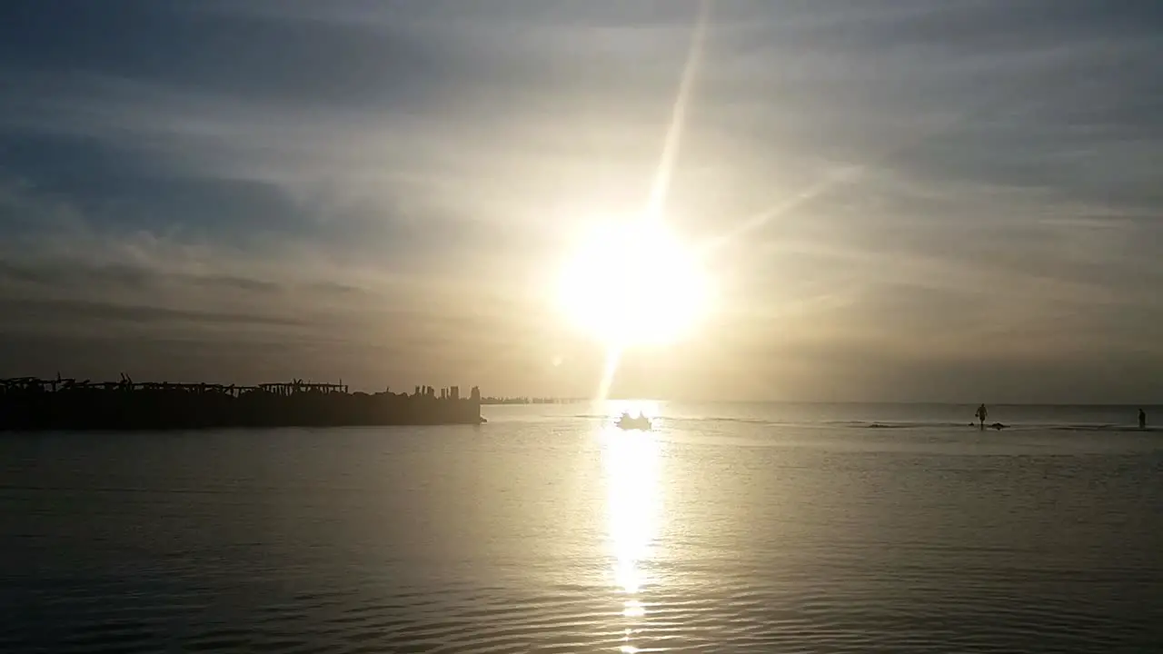 Fishing boat at sea sunset rays and wooden pier