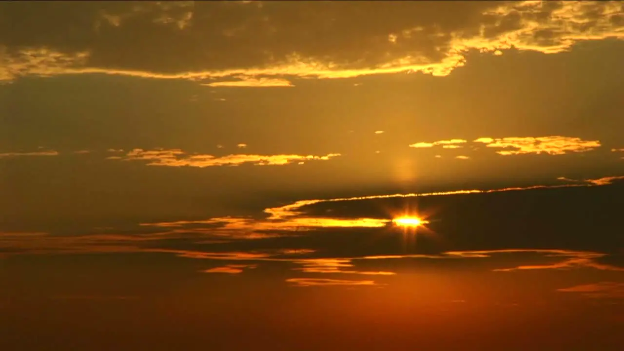 A golden sun peeks through a bank of clouds