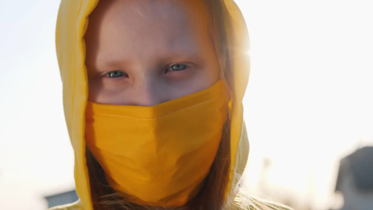 Portrait Of A Girl In A Yellow Hood And A Yellow Protective Mask