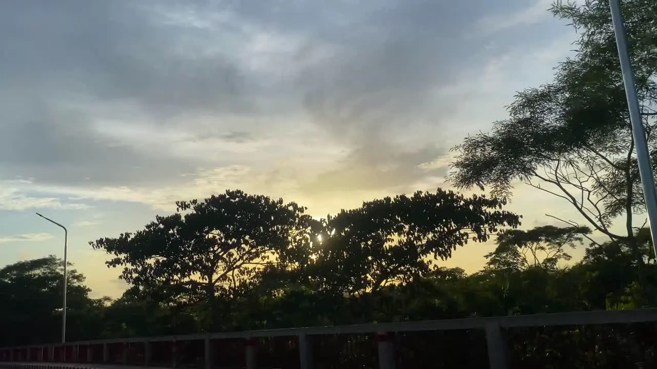 POV Driving Across Road During Golden Yellow Sunset Over Trees In Sylhet