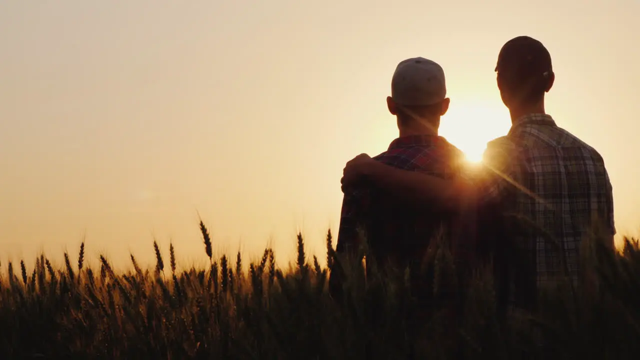 Two Young Men Hugging Against The Backdrop Of The Sunset Looking Forward To The Horizon