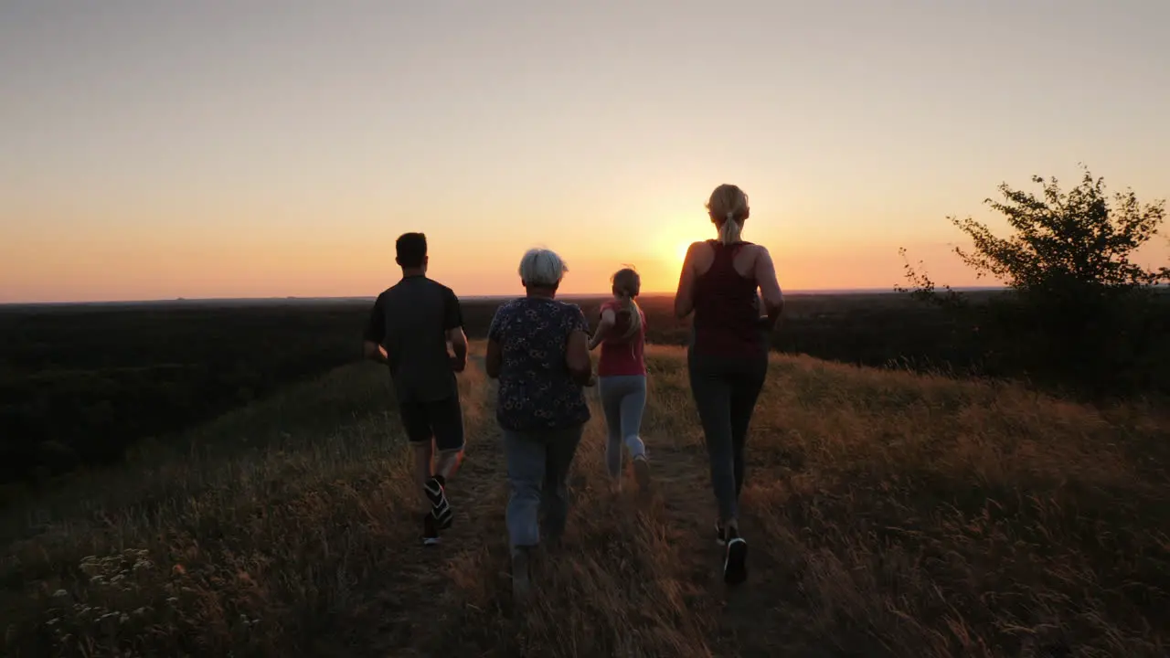 A Friendly Family Of Four Jogs Together Grandmother Mom With Dad And Baby