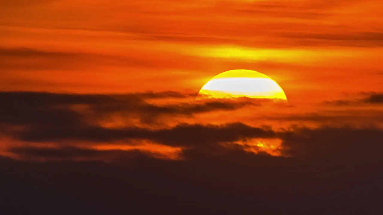 Time lapse of the nearby sun rising through the clouds in a beautiful sunrise