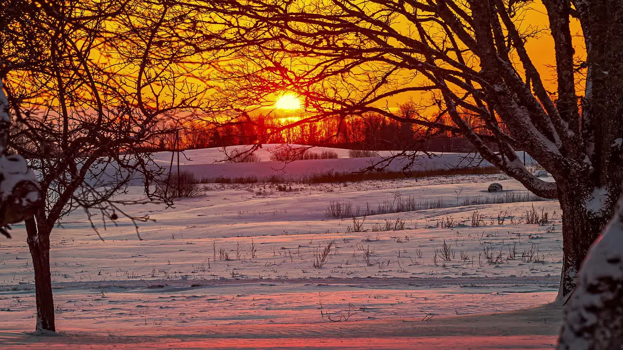 Golden dawn as sunrise glows and reflects off the snowy landscape time lapse