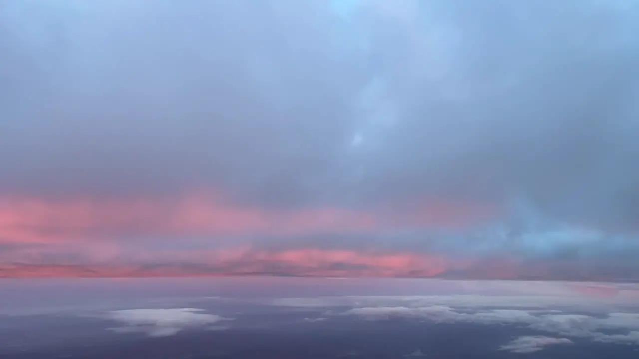 Aerial jet cockpit view while flying just bellow a layer of winter snow clouds