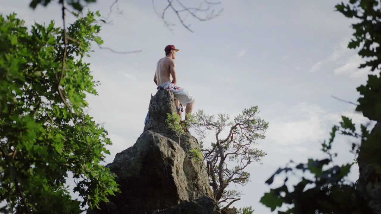 peaceful mountain top picknick man having a break in flowerfield stone tower enjoying the view taking in the sight landscape overview cinematic slow motion slomo male guy enjoys outdoor hills