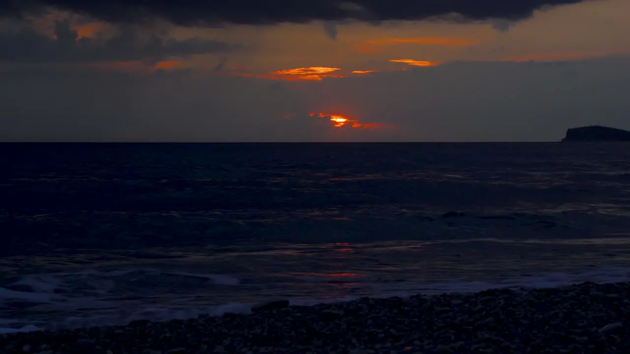 Dark sea under clouds and glowing sky at sunset dramatic seascape on Ionian coastline