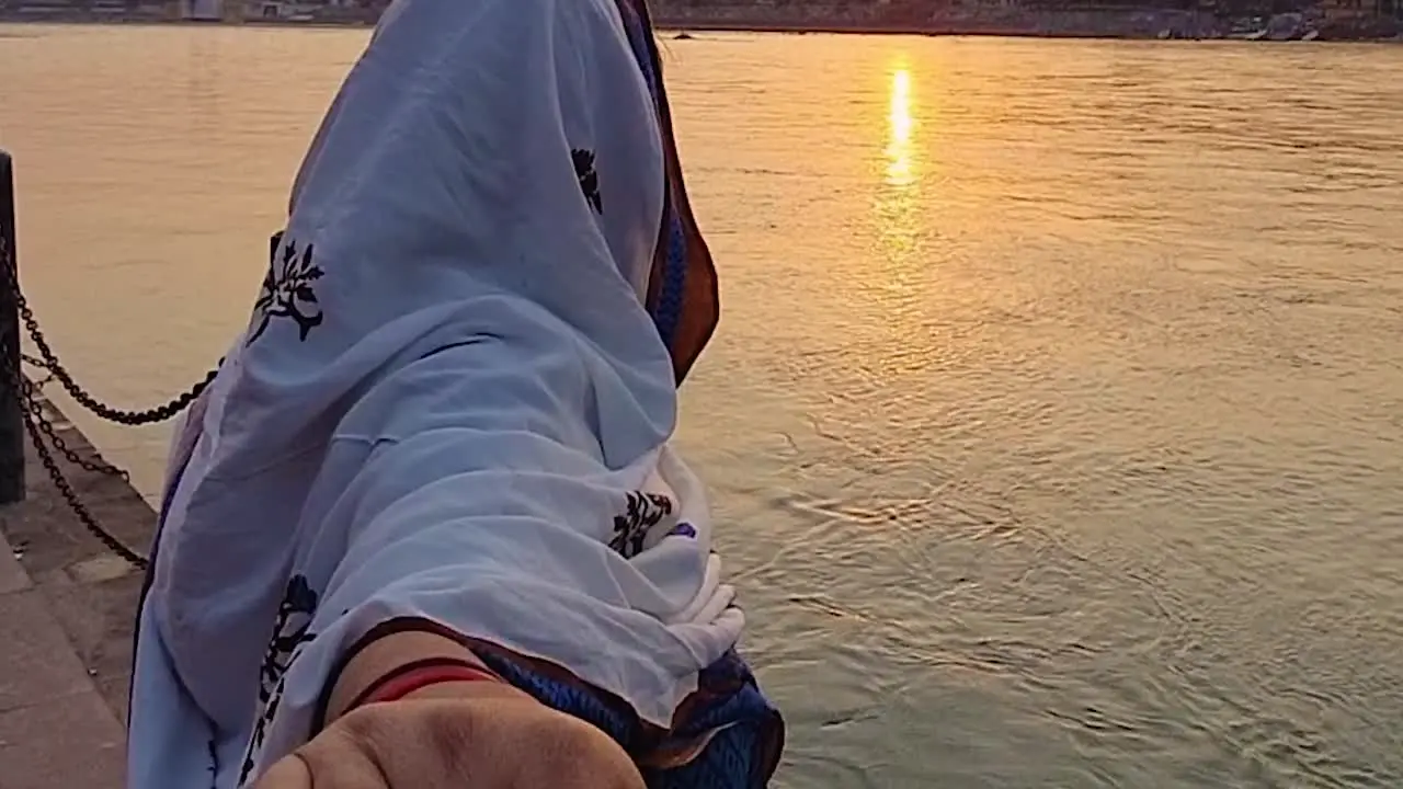 couple holding each other at river shore at sunset from flat angle video is taken rishikesh uttrakhand india on Mar 15 2022