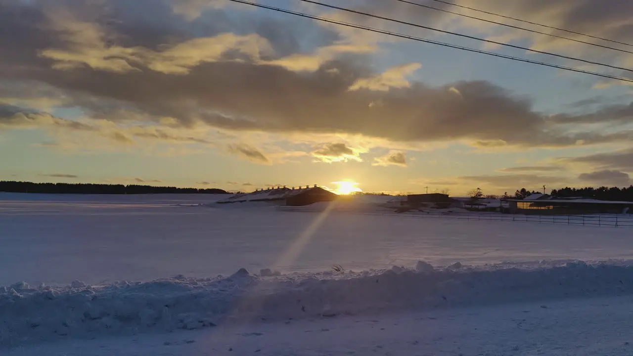 Driving Past Golden Sunset Past Farm Buried In Deep Snow In Hokkaido