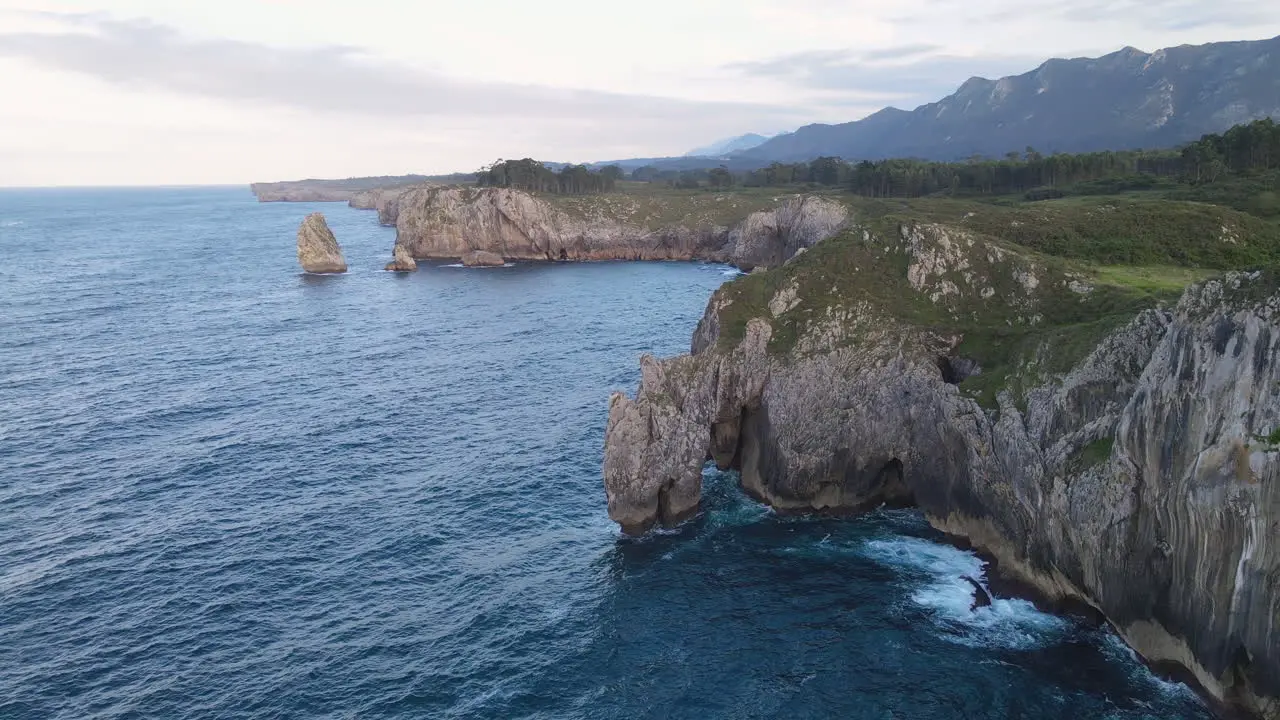 Aerial View Of Sea Waves Breaking On Rocky Coastline