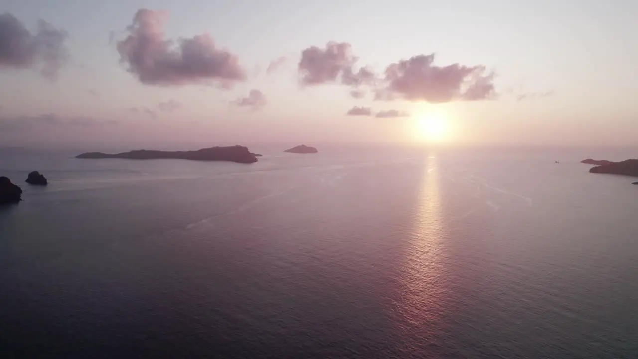 Almost no clouds During Orange Sunset with Calm Sea and islands aerial shot